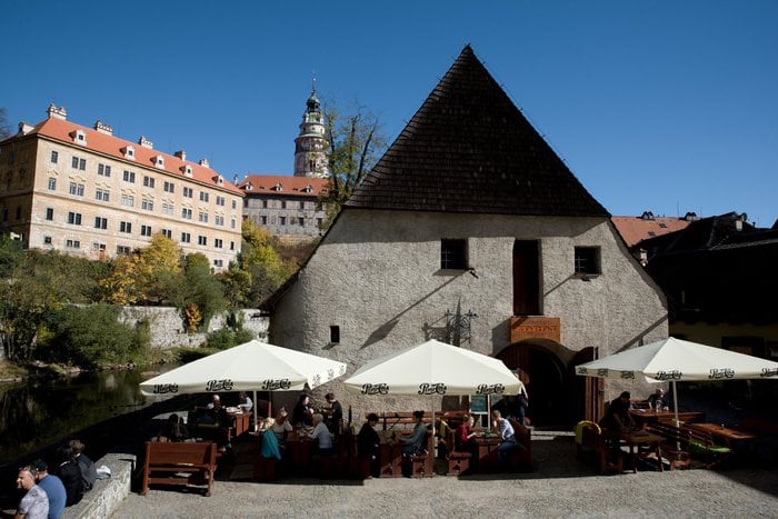 Restaurant ZDROJ v historické budově se štítem nad řekou v Českém Krumlově